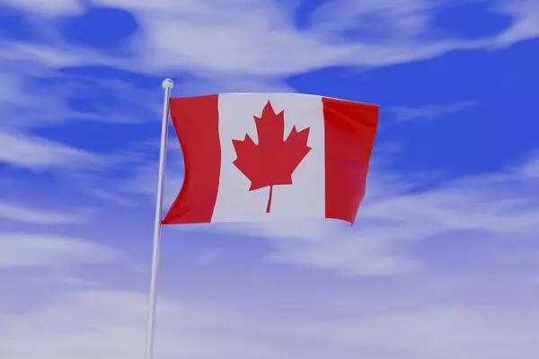 Canadian flag against a sky blue background with clouds