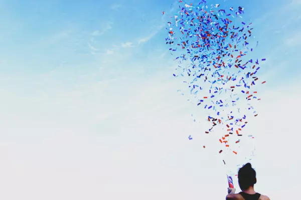 Red white and blue confetti against a blue sky