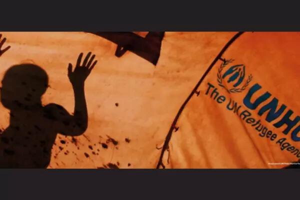 The outline of a person with their arm up and the UNHCR logo