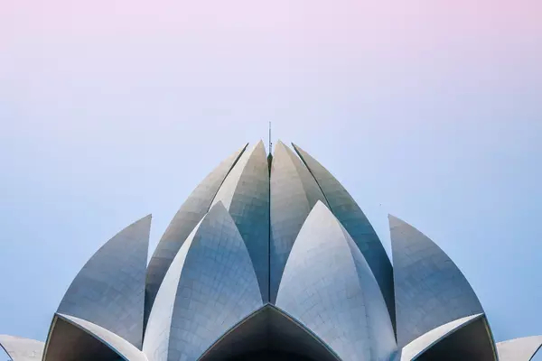 The Lotus Temple in India against a blue and pink sky. 