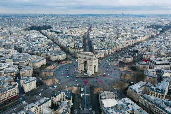 Aerial photo of the Arc de Triomphe and the city of Paris surrounding it