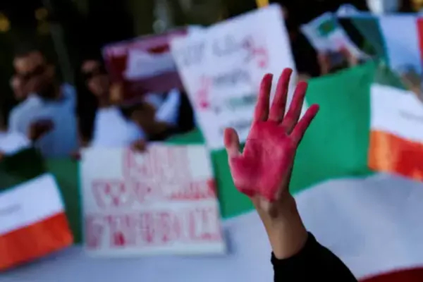 A hand painted red is raised in protest against violence directed at women in Iran