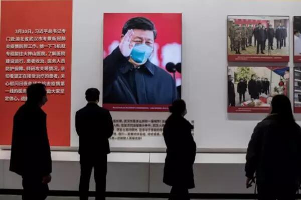 People look at a picture of Chinese leader Xi Jinping during an exhibition about China's fight against COVID-19 at a convention center that was previously used as a makeshift hospital for patients in Wuhan, China, on Jan. 15, 2021. | AFP-JIJI