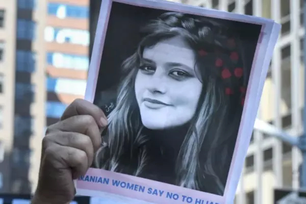 Mahsa Amini's face has become an international symbol for unrest within Iran after she died in police custody in September after allegedly violating the country's strict hijab rules. Here, people hold up a photo of Amini as they participate in a protest against Iranian President Ebrahim Raisi outside of the United Nations on Sept. 21 in New York City. (Stephanie Keith/Getty Images)