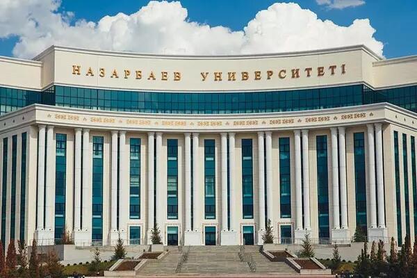 An impressive building, part of Nazarbayev University, against a blue sky.