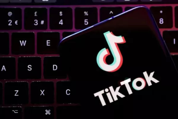 TikTok Logo on a phone screen, laying on a laptop keyboard