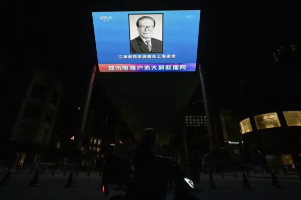 A news broadcast featuring an image of the former Chinese leader Jiang Zemin in Beijing on Wednesday. How President Xi Jinping orchestrates tributes to him will be a test in the coming days.