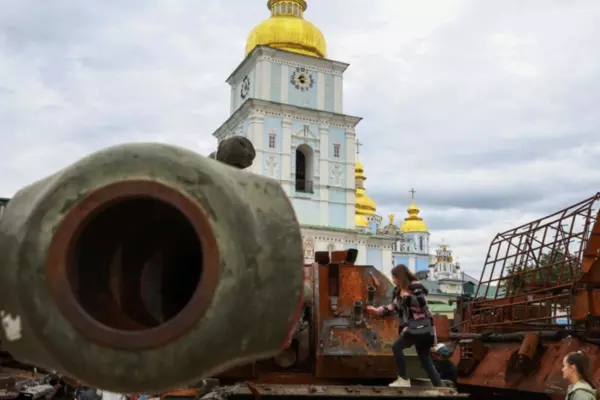 A child plays on top of an exhibition of destroyed Russian military vehicles and weapons outside St. Michael's Cathedral in Kyiv.