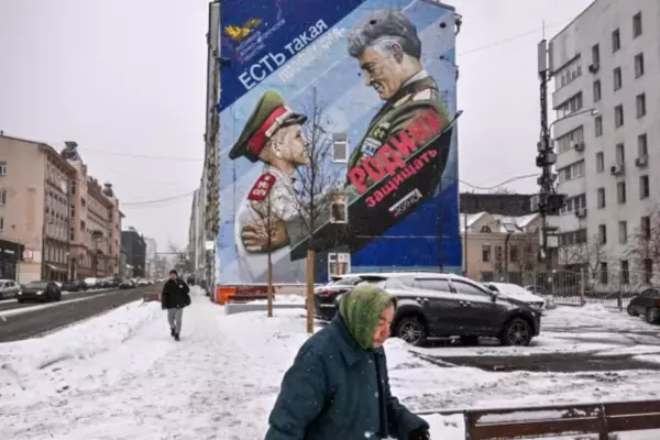 A pedestrian walks past a mural depicting a Russian general and a cadet with a slogan reading: 'There is such a profession — to defend the homeland,' in Moscow earlier this month.