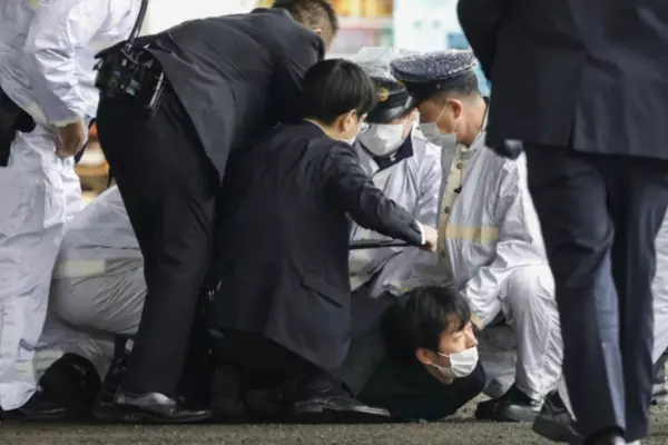 A man believed to be a suspect, centre on the ground, is caught by police after he allegedly threw "the suspicious object," as Japanese Prime Minister Fumio Kishida visited Saikazaki port for an election campaign event in Wakayama, western Japan, April 15, 2023. (Kyodo News via AP)