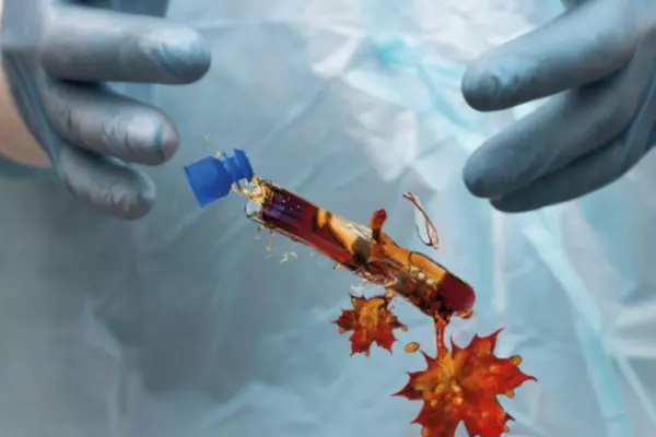 A dropped test tube morphing into liquid with maple leaves