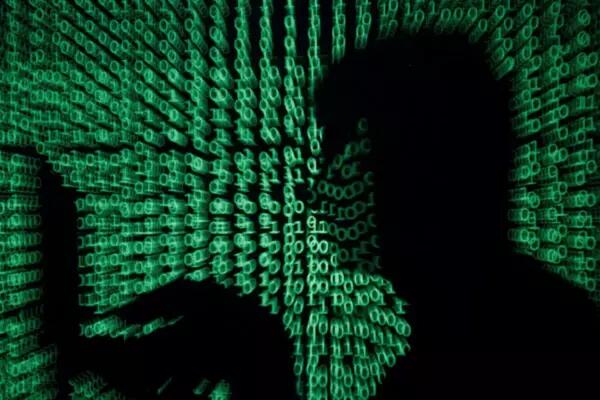 A man holds a laptop computer as cyber code is projected on him in this illustration picture taken on May 13, 2017. REUTERS/Kacper Pempel/Illustration Acquire Licensing Rights