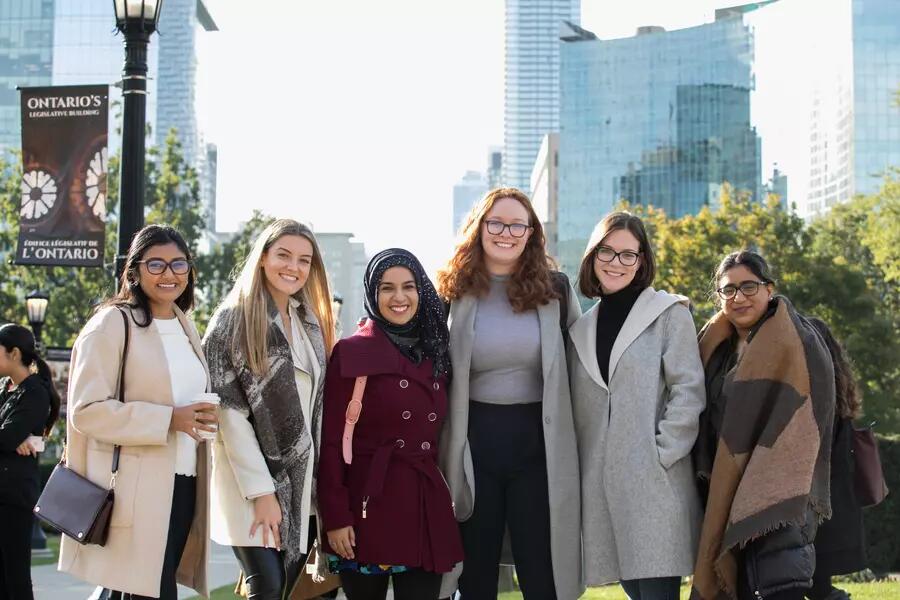 Six female MPP students smiling against an urban skyline