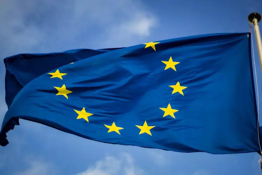 The EU flag on a flag pole against a blue sky