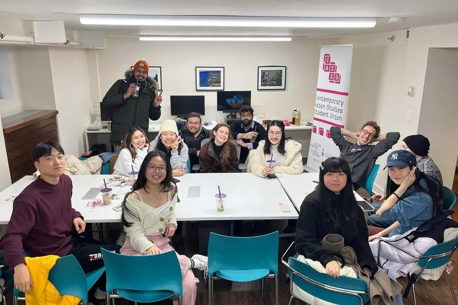 A group of students in the Asian Institute student lab smile at the camera while attending a Contemporary Asian Studies Student Union social event.