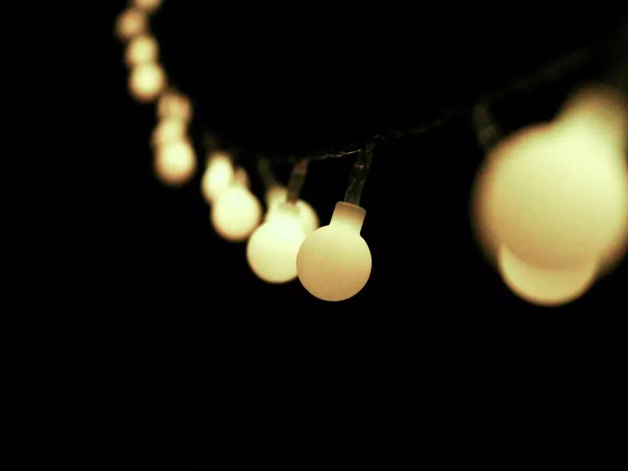 String of lightbulbs hanging against a dark space