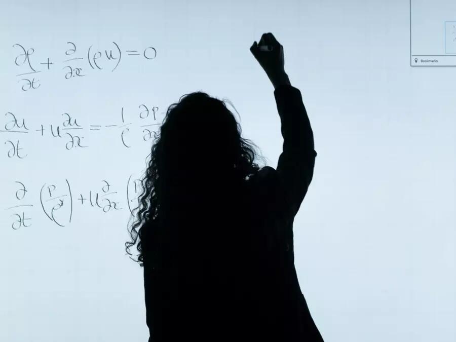 Woman working with a math equation on a whiteboard