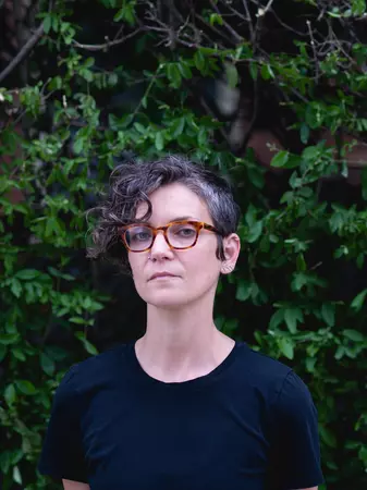Picture of Zoe Wool in a black t-shirt standing in front of a tree
