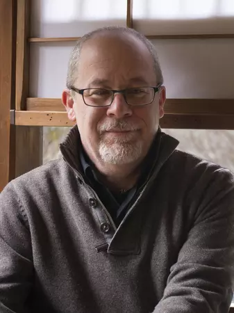 Picture of Rick Halpern in front of a window wearing glasses and a grey sweater.
