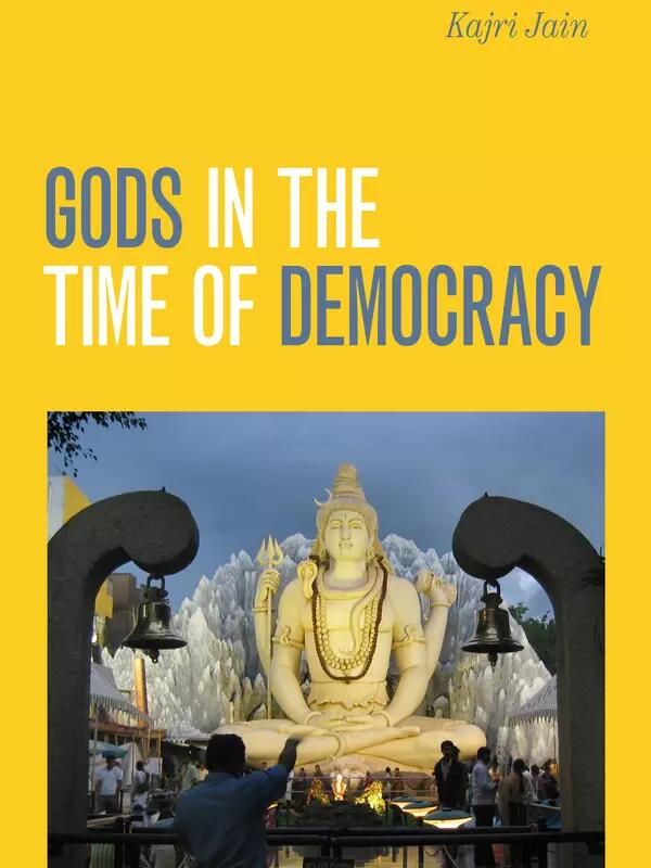 Book cover: Kajri Jain, Gods in the Time of Democracy. Image of a large Hindu statue lit up, with people crowded below. 