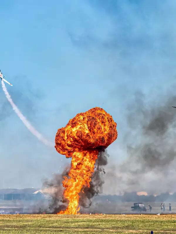 Small explosion in a field, as planes fly away.