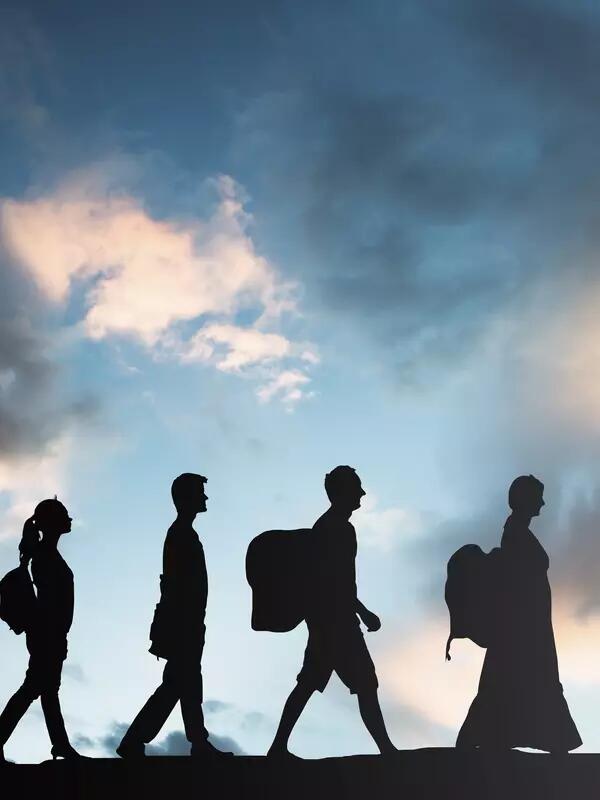 silhouette of refugees walking in a row