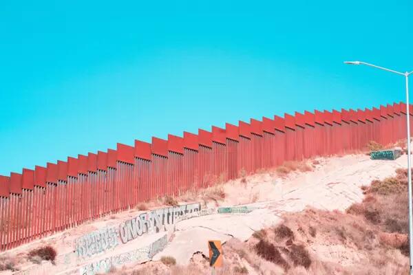 A pink wall built on a hill with a blue sky above
