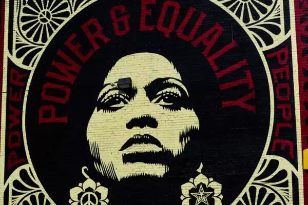 A mural of a woman's face with the words Power & Equality written in a circle above her head