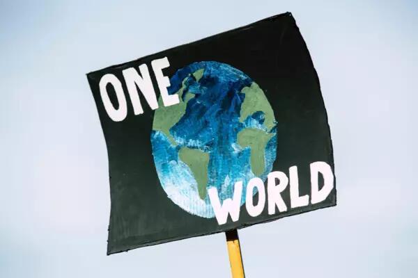 A sign with a drawing of the planet and the words One World written on it