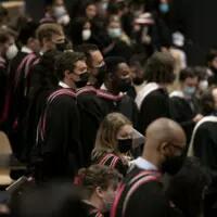 Standing students ready to receive their degree