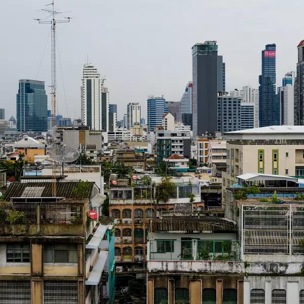 A view of the Bangkok skyline, including some dilapidated older buildings and newer buildings in the background.