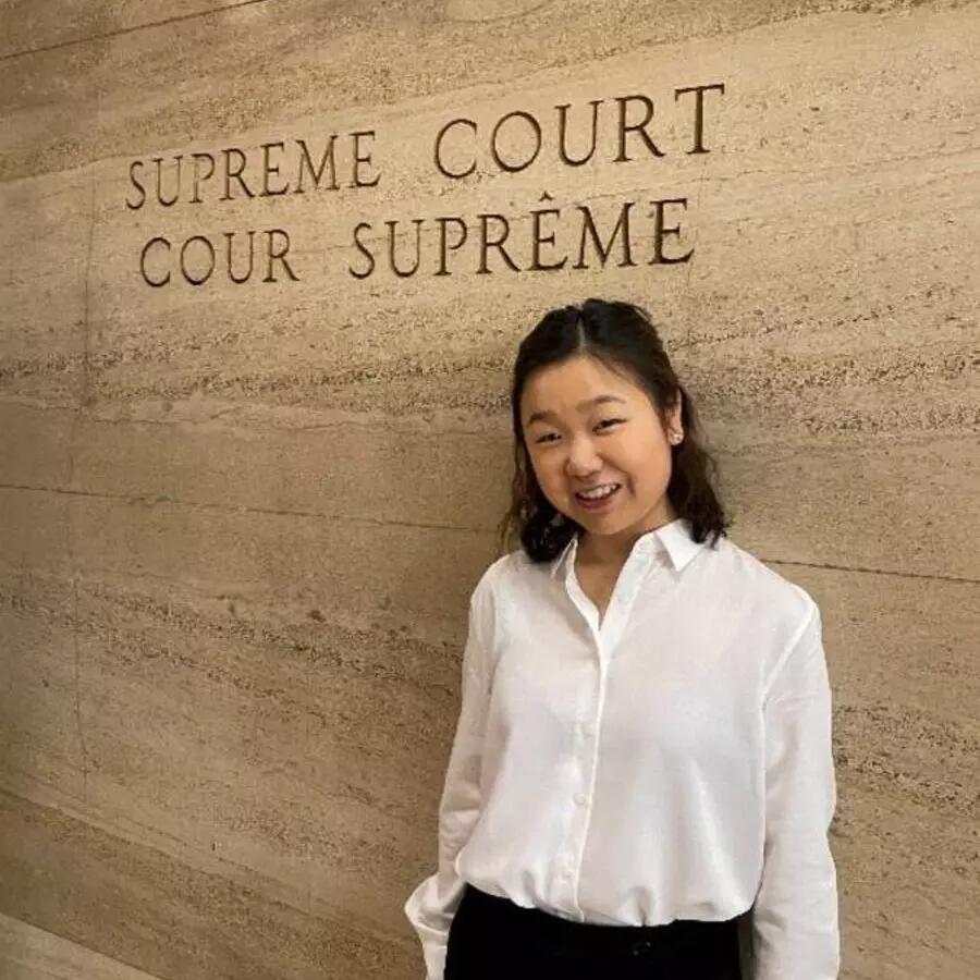 Headshot of Christal Cheng standing in front of the Supreme Court sign