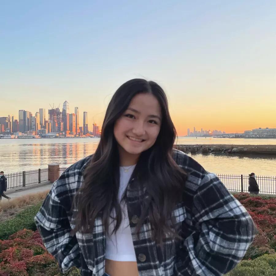 Girl wearing flannel shirt standing in front of city skyline